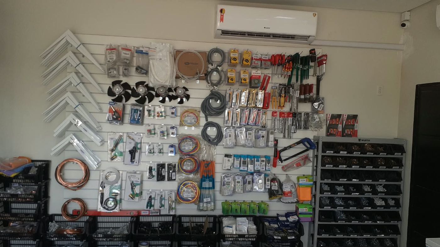 Parede da loja com suportes de condensadora, motores ventiladores, mangueiras e controles remotos